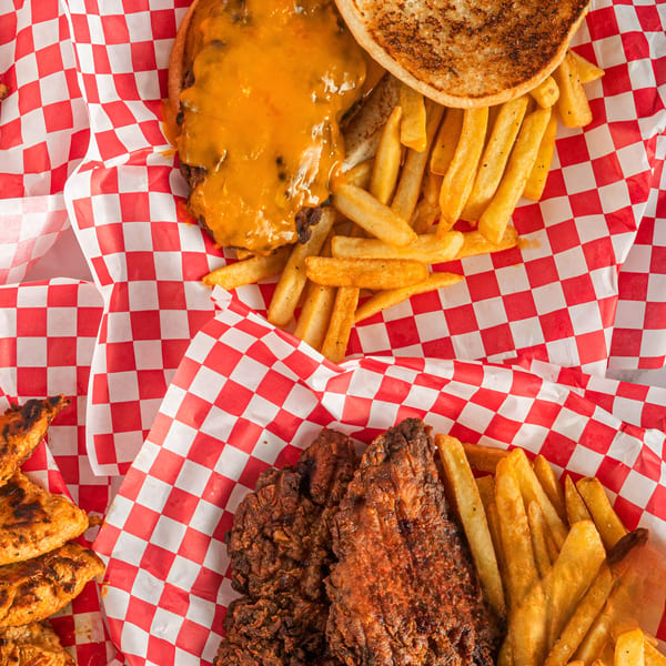 Cheeseburger with fries and Hot Chicken and Breakfast's fried chicken with fries, on red checkered paper.