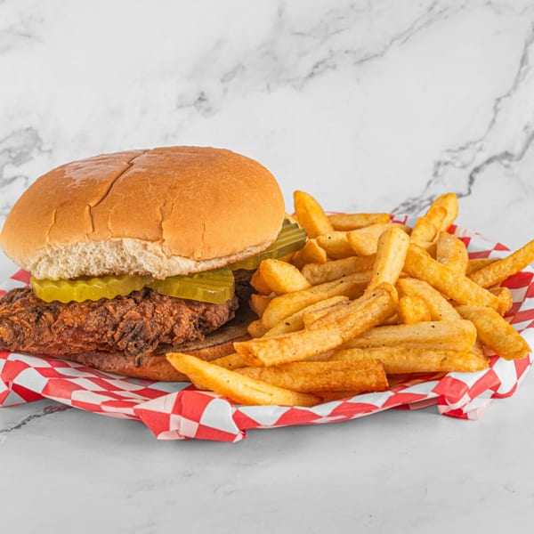 Hot Chicken and Breakfast's crispy chicken sandwich with pickles and a side of golden fries.