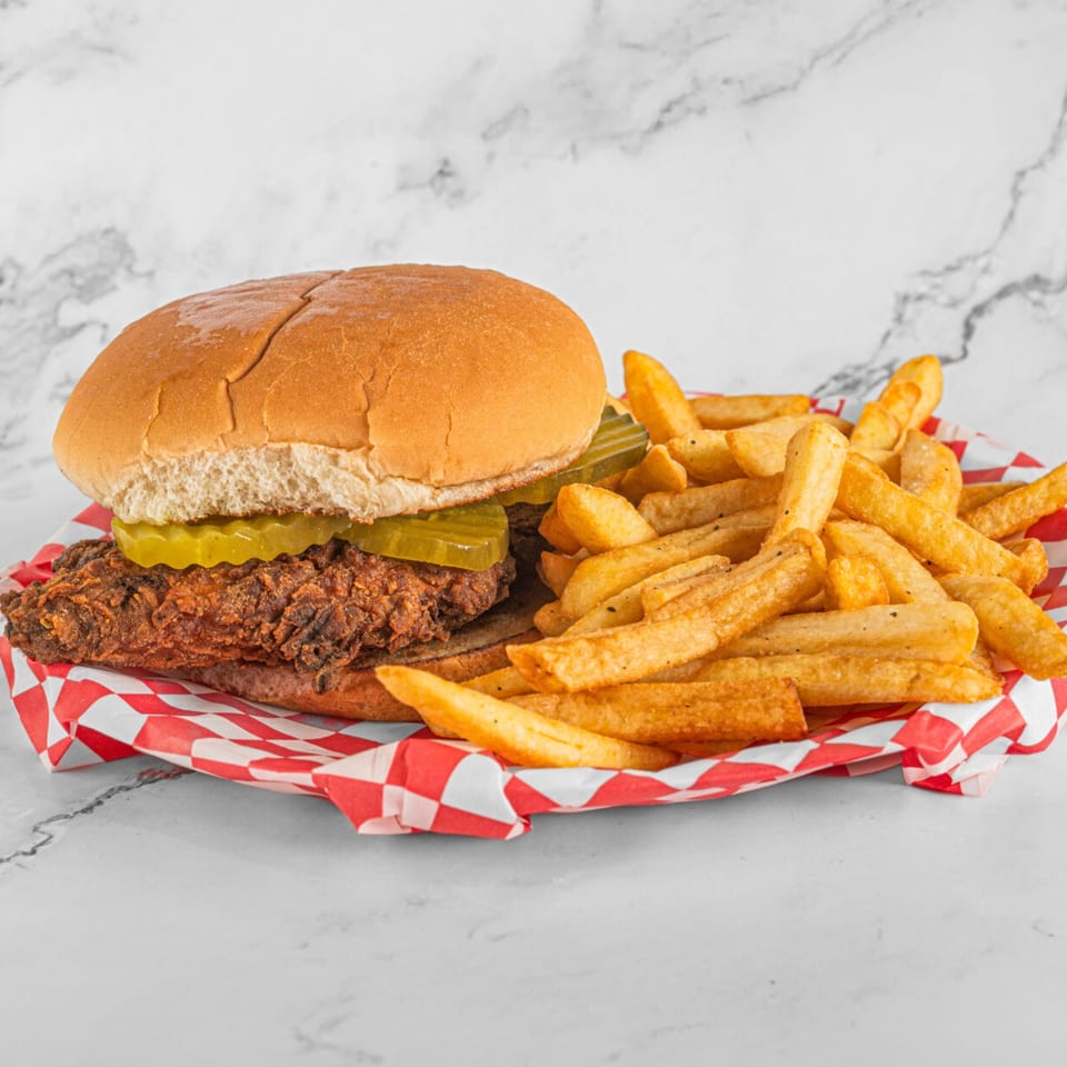Hot Chicken and Breakfast's crispy fried chicken sandwich with pickles and a side of french fries.